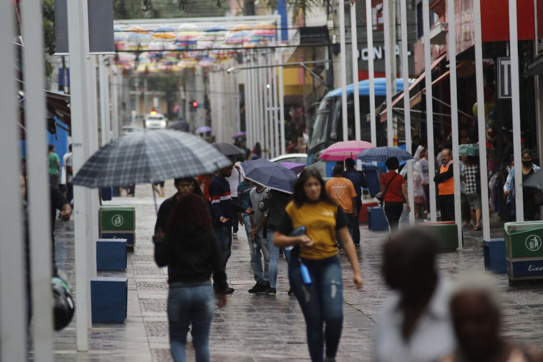 Pedestres se protegem da chuva no Centro de Campinas (Foto: Denny Cesare/ Código 19)