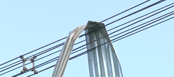 Perigo: Telha de zinco, que literalmente voou, foi parar em cima de cabos elétricos da rede de alta tensão (Foto: Reprodução/ EPTV)