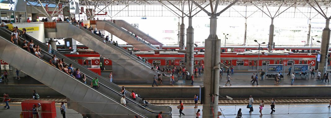 A foto mostra a estaçãoda CPTM em São Paulo com trens e pessoas circulando