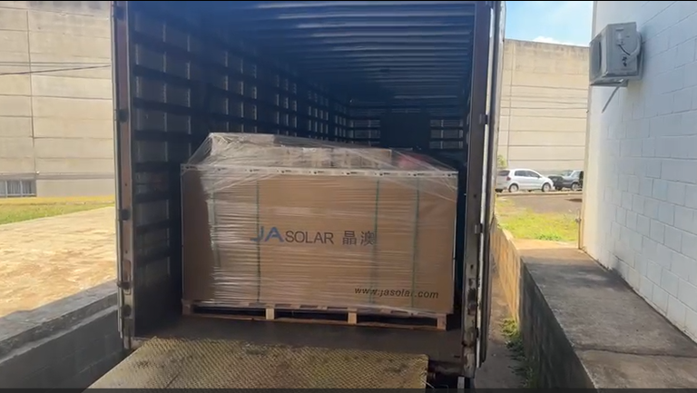 A foto mostra equipamentos de energia solar, embalados, dentro de um caminhão