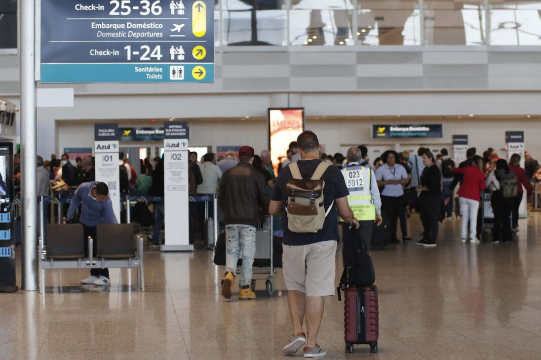 foto mostra passageiros andando no aeroporto de Viracopos, com bagagens