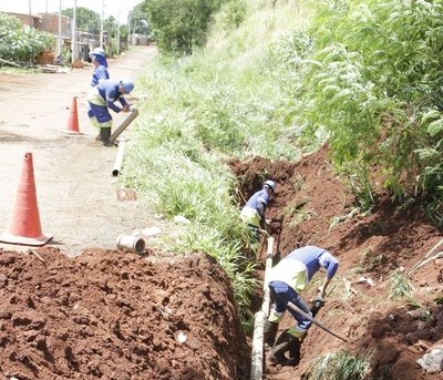 A foto mostra funcionários da Sanasa trabalhando em uma obra em uma rua de terra em Campinas