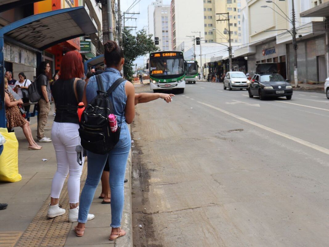 foto mostra algumas pessoas sinalizando parada para um ônibus na Campos Sales