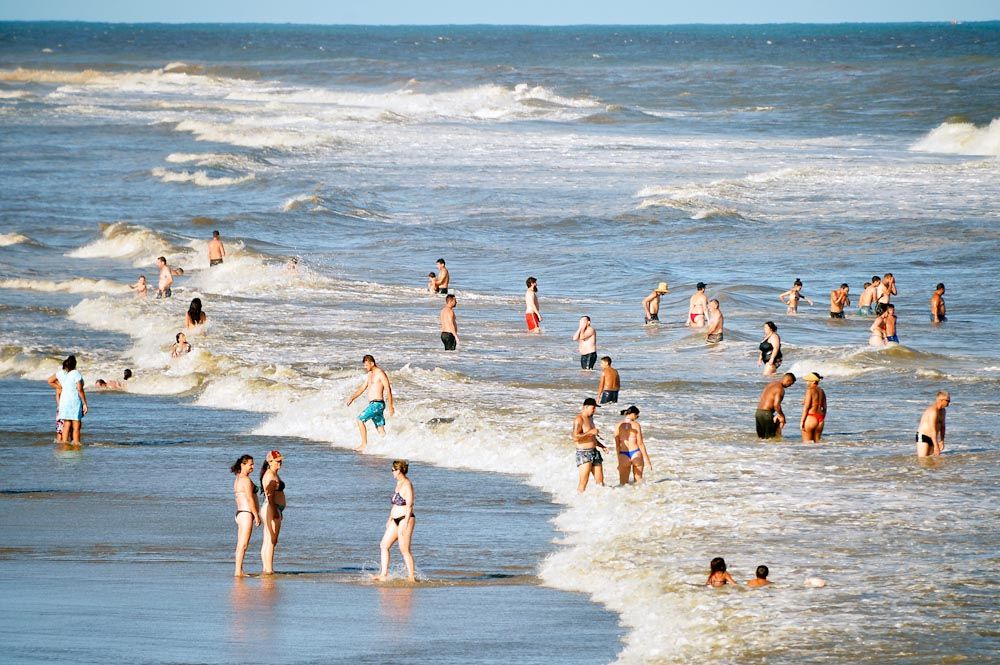 a foto mostra banhistas no mar de uma praia - praias impróprias SP