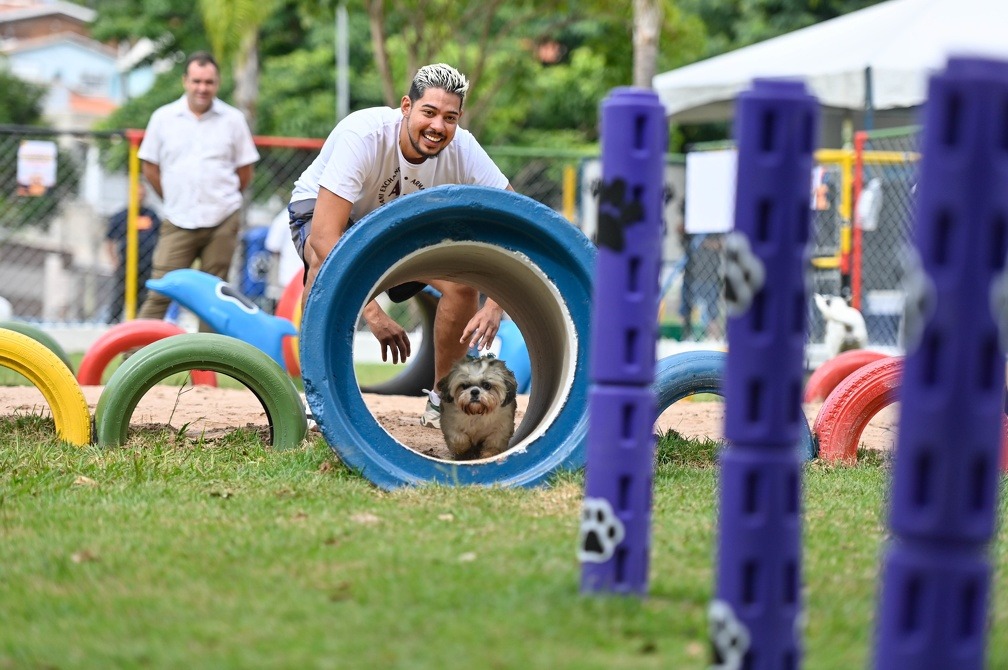 foto mostra um tutor com seu cão no parque para cachorros