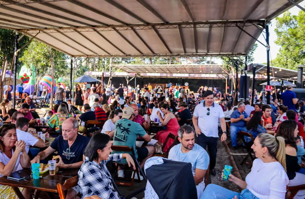 A foto mostra pessoas sentadas em mesas durnte o festival de cerveja no shopping