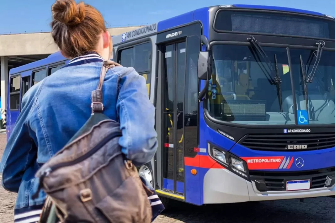 A foto mostra uma jovem de mochila chegando perto de um ônibus da EMTU