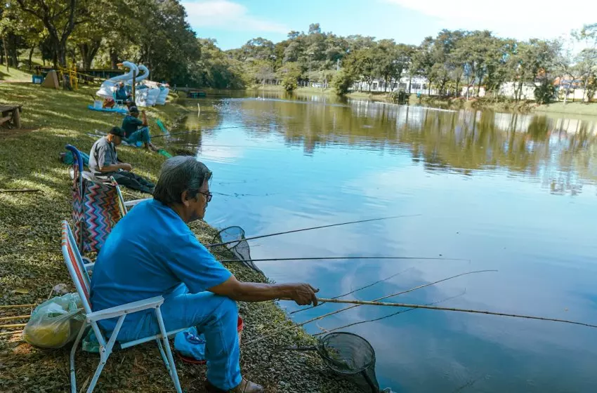 a foto mostra um homem pescando no lago