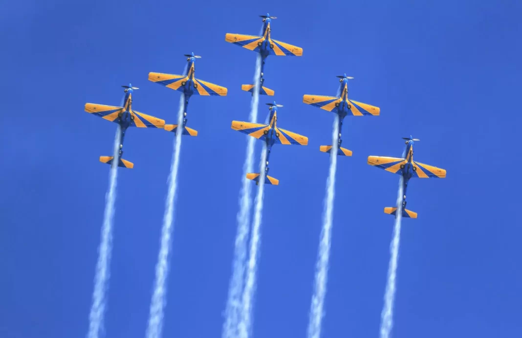 a foto mostra os aviões da esqudrilha voando e soltando fumaça