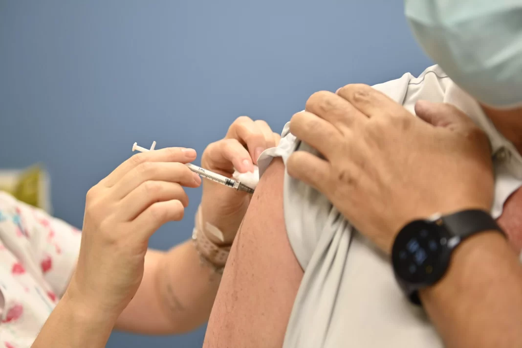 a foto mostra uma pessoa recebendo a vacina bivalente