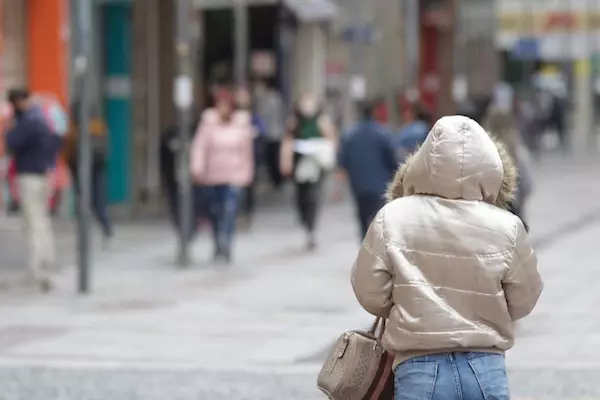 a foto mostra uma mulher caminhando com roupas de frios