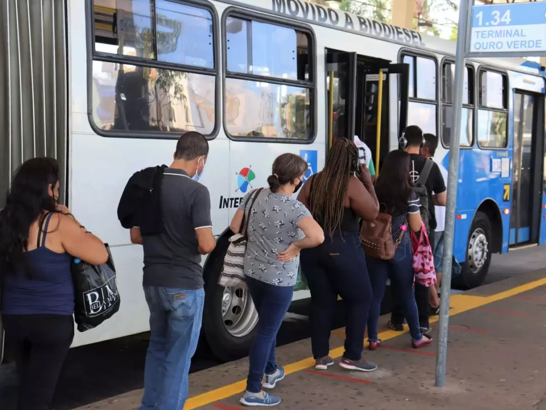 a foto mostra pessoas entrando em um ônibus