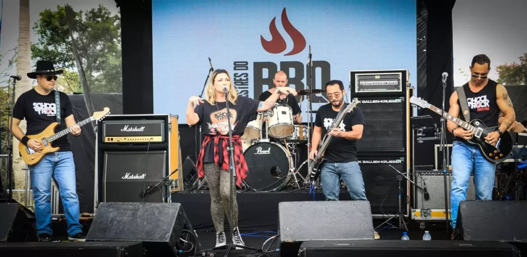 a foto mostra uma banda se apresentante em um palco no festival