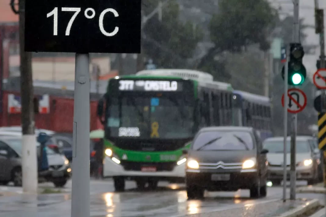 a foto mostra um termômetro de rua marcando 17°C, com alguns veículos atrás - frente fria