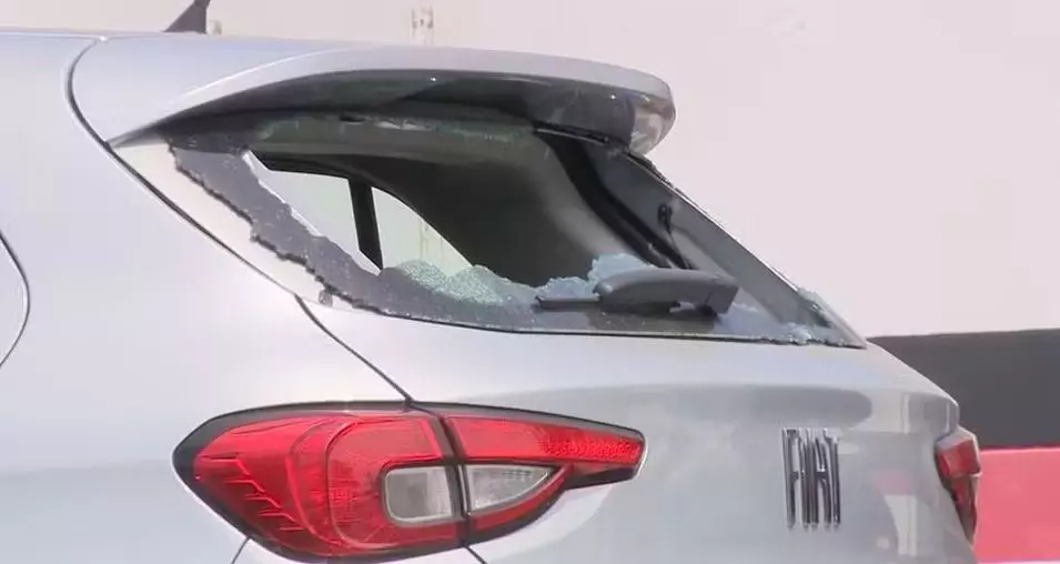 a foto mostra a parte de trás de um carro com o vidro quebrado