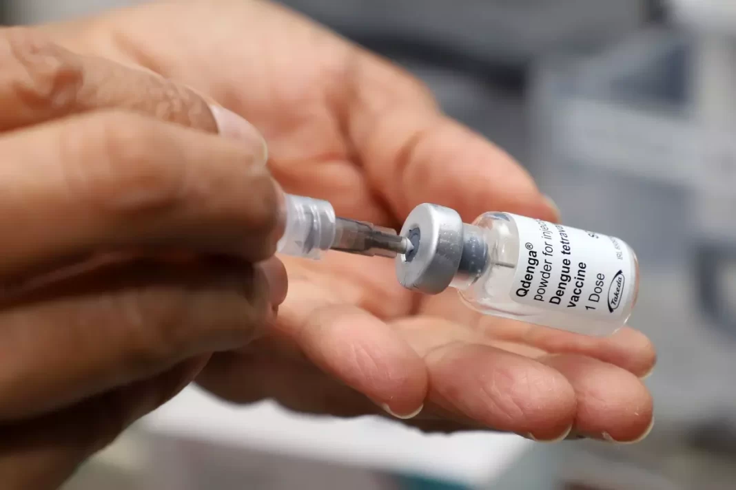 a foto mostra a mão de uma pessoa com uma seringa e uma dose de vacina - centros de saúde