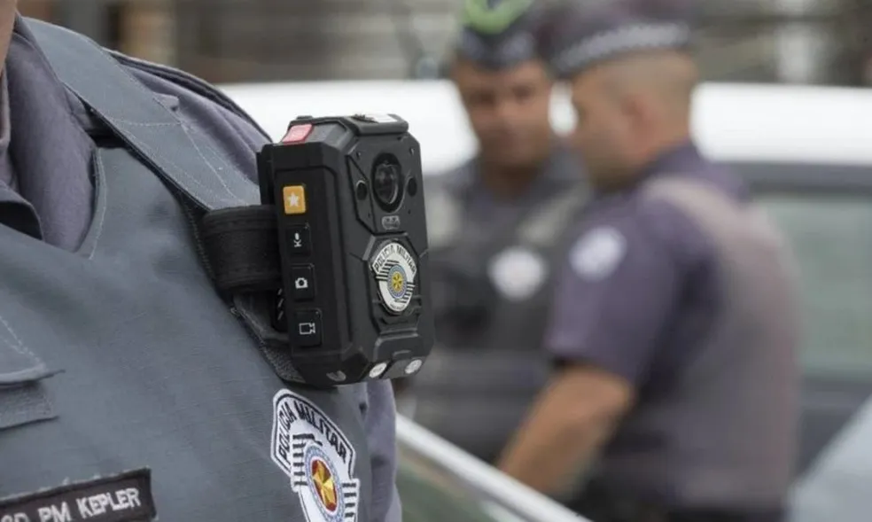 a foto mostra um policial usando uma câmera corporal