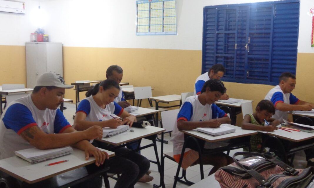 a foto mostra estudantes sentados em uma sala de aula