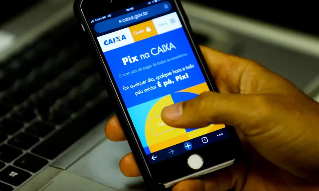 a foto mostra uma mão segurando um celular em um aplicativo de banco no PIX