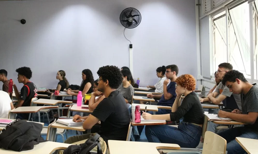 a foto mostra várias pessoas fazendo prova em uma sala de aula - enem dos concursos