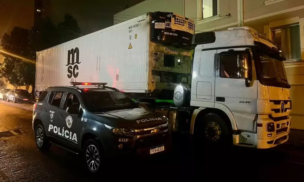 a foto mostra o caminhão e uma viatura policial