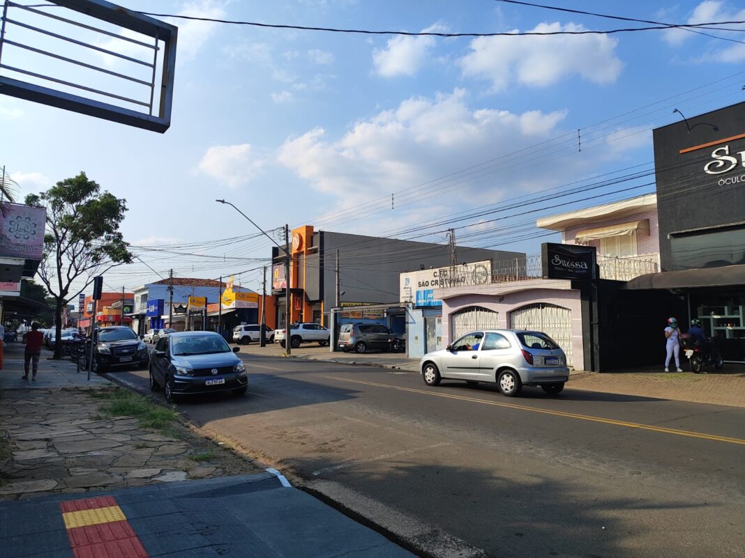 Avenida Sallum, em São Carlos, com veículos passando em uma paisagem urbana.