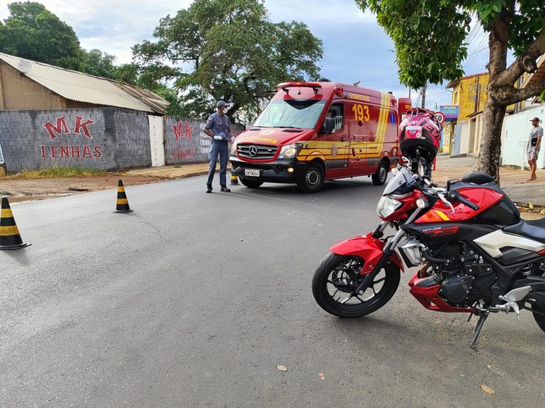 A foto mostra uma moto vermelha e uma ambulância vermelha dos Bombeiros em via pública