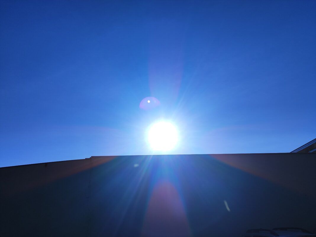 A foto mostra o sol em meio a um céu azul aberto