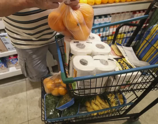 A foto mostra um senhor segurando uma sacola de laranjas e empurrando um carrinho de supermercado (Foto: Agência Brasil)