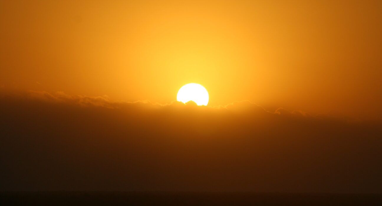 A imagem mostra um sol se pondo