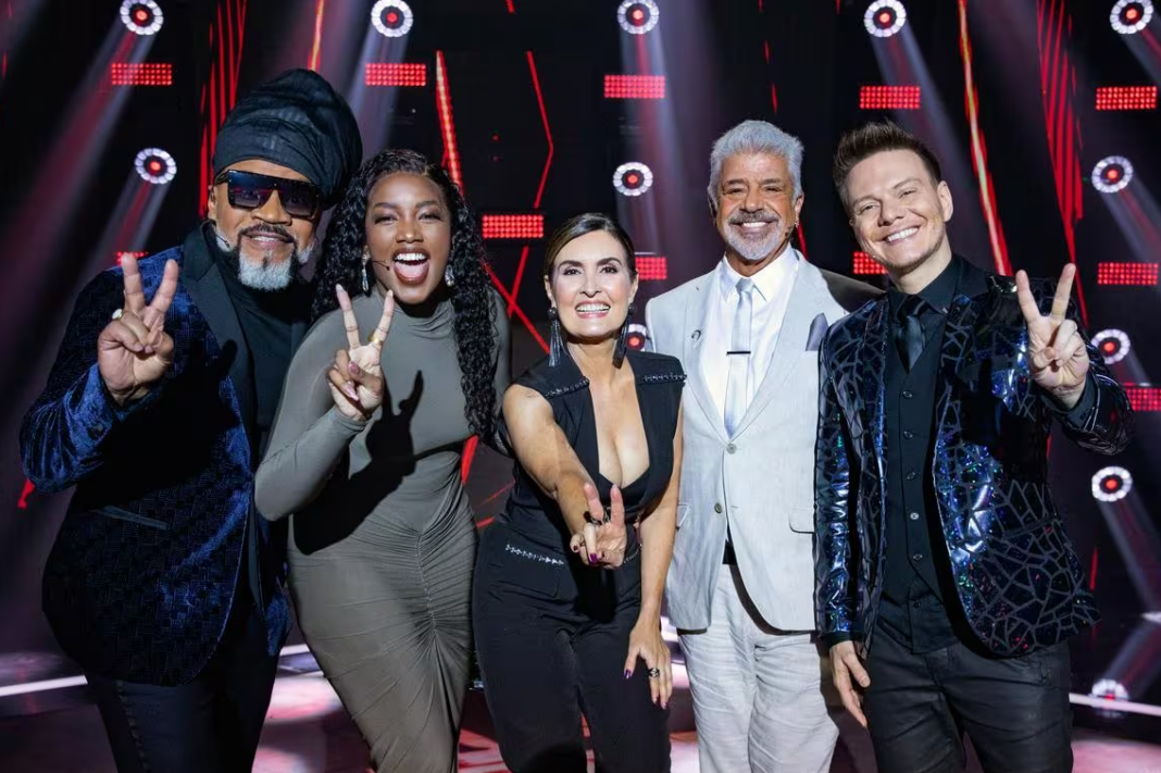 A foto mostra o elenco de The Voice Brasil, na esquerda está Carlinhos Brown, Iza, Fátima Bernardes, Lulu Santos e Michel Teló